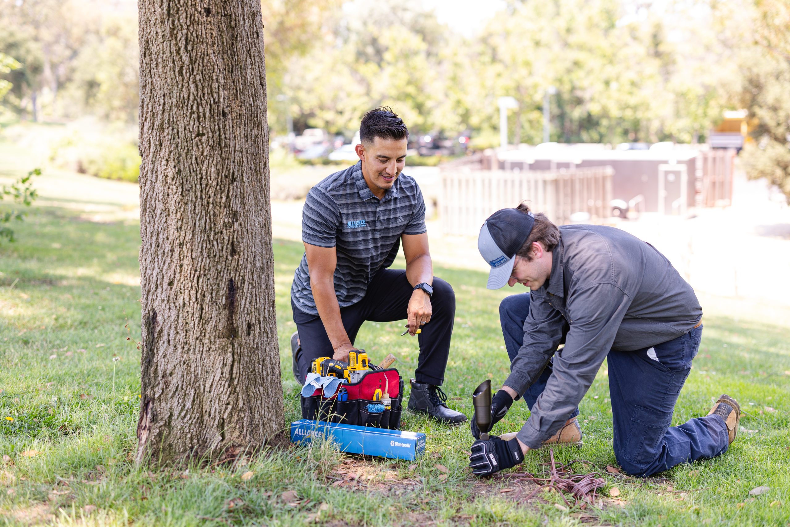 Alliance Outdoor Lighting rep assisting contractor with first low voltage outdoor lighting installation, reviewing fixture placement and wiring tips on-site.
